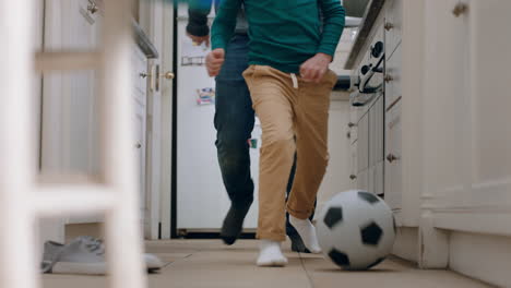 Vater-Und-Sohn-Spielen-Fußball-In-Der-Küche-Und-Treten-Fußball.-Kind-Genießt-Das-Spiel-Mit-Papa-Zu-Hause
