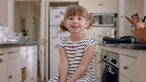 Porträt-Eines-Schönen-Kleinen-Mädchens,-Das-Mit-Niedlichem-Gesichtsausdruck-Lächelt-Und-Zu-Hause-In-Der-Küche-Sitzt
