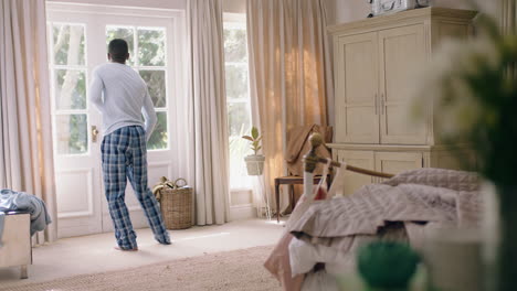 funny-african-american-man-dancing-in-bedroom-having-fun-celebrating-feeling-positive-enjoying-successful-lifestyle-doing-silly-dance-at-home-on-weekend-morning-wearing-pajamas