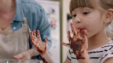 Fröhliches-Kleines-Mädchen-Mit-Mit-Schokolade-Bedeckten-Händen,-Das-Sich-Die-Finger-Leckt-Und-Spaß-Beim-Backen-In-Der-Küche-Hat.-Unartiges-Spielendes-Kind,-Das-Die-Kindheit-Genießt