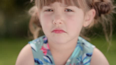 Porträt-Eines-Schönen-Kleinen-Mädchens,-Das-Mit-Neugierigem-Gesichtsausdruck-In-Die-Kamera-Blickt,-Süßes-Kind-Im-Sonnigen-Park,-4K-Videos