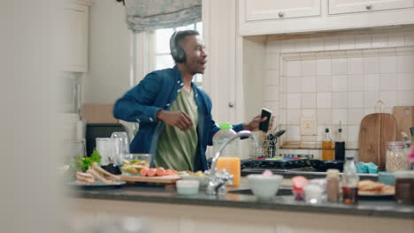happy-african-american-man-dancing-in-kitchen-listening-to-music-wearing-headphones-having-fun-dance-celebration-enjoying-weekend-at-home