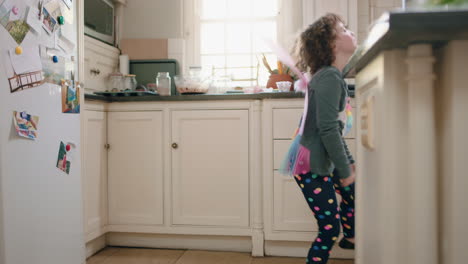 happy-little-girl-dancing-in-kitchen-wearing-cute-fairy-wings-having-fun-waving-spoon-playing-pretend-doing-funny-dance-moves-enjoying-weekend-at-home