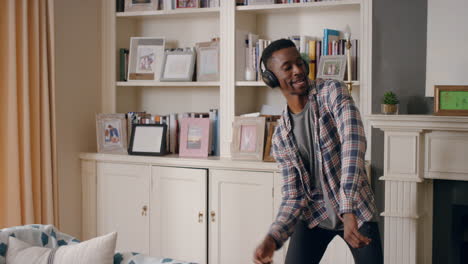 funny-african-american-man-dancing-at-home-wearing-headphones-celebrating-success-listening-to-music-having-fun-crazy-dance-in-living-room-happy-lifestyle-4k