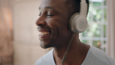 Glücklicher-Afroamerikanischer-Mann,-Der-Es-Genießt,-Musik-Zu-Hören,-Kopfhörer-Zu-Tragen-Und-Sich-Positiv-Zu-Fühlen-Und-Spaß-Beim-Entspannen-Zu-Hause-Zu-Haben