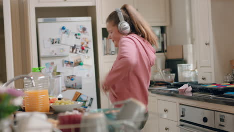 happy-teenage-girl-dancing-in-kitchen-having-fun-celebrating-weekend-performing-funny-dance-moves-listening-to-music-wearing-headphones