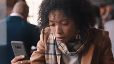 Schöne-Afroamerikanische-Frau-Nutzt-Ihr-Smartphone,-Trinkt-Kaffee-Im-Café-Und-Schreibt-SMS,-Teilt-Nachrichten-In-Sozialen-Medien-Und-Genießt-Mobile-Technologie-In-Einem-Belebten-Restaurant