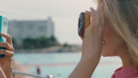 beautiful-woman-posing-with-donuts-on-beach-best-friend-taking-photos-using-smartphone-sharing-weekend-by-seaside-on-social-media-enjoying-summertime-fun-4k