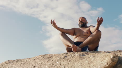 Afroamerikanischer-Mann-Meditiert-Am-Strand-Und-übt-Achtsamkeit,-Entspannt-Sich-Im-Freien-Und-Genießt-Die-Ruhige-Küste-In-4K