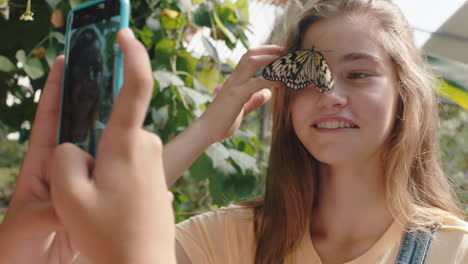 beautiful-butterfly-on-girls-face-with-happy-friend-taking-photo-using-smartphone-friends-having-fun-in-zoo-wildlife-sanctuary-sharing-nature-excursion-on-social-media-4k-footage