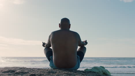 Hombre-Afroamericano-Meditando-En-La-Playa-Practicando-Atención-Plena-Relajándose-Al-Aire-Libre-Disfrutando-De-La-Tranquila-Playa-4k