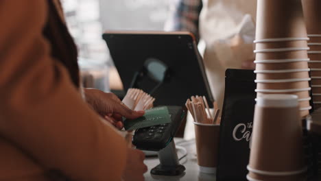 Glücklicher-Barista-Mann,-Der-Kunden-Bedient,-Die-Mit-Kreditkarte-Bezahlen,-Kontaktloses-Bezahlen,-Geld-Ausgeben,-Um-Kaffee-Im-Café-Zu-Kaufen