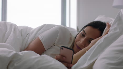 happy-woman-using-smartphone-in-bed-texting-sharing-social-media-messages-enjoying-online-connection-relaxing-at-home