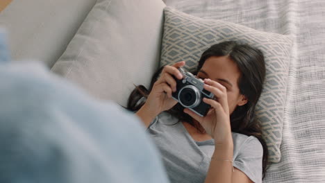 happy-couple-taking-photos-together-using-camera-having-fun-relaxing-at-home-on-sofa-enjoying-romantic-relationship-playfully-photographing-each-other