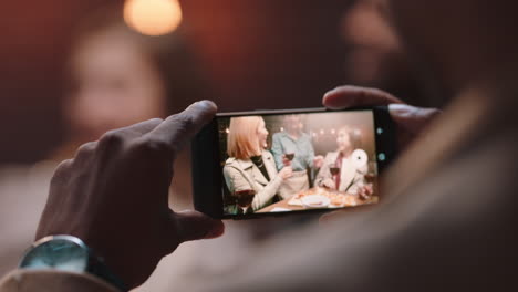 close-up-man-using-smartphone-taking-photo-of-friends-celebrating-making-toast-sharing-celebration-party-on-social-media-enjoying-making-memories