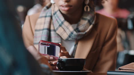 Schöne-Afroamerikanische-Frau-Benutzt-Smartphone-Im-Café-Und-Schreibt-SMS,-Teilt-Nachrichten-In-Sozialen-Medien-Und-Genießt-Mobile-Technologie-In-Einem-Belebten-Restaurant
