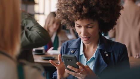 Schöne-Frau-Mit-Afro-Frisur-Nutzt-Ihr-Smartphone-Im-Café-Und-Schreibt-SMS,-Teilt-Nachrichten-In-Sozialen-Medien-Und-Genießt-Mobile-Technologie