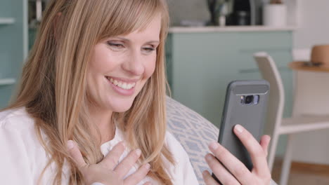 beautiful-blonde-woman-having-video-chat-using-smartphone-smiling-looking-excited-enjoying-good-news-chatting-to-friend-on-mobile-phone-at-home