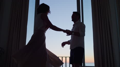 silhouette-happy-couple-dancing-in-hotel-room-at-sunset-enjoying-honeymoon-vacation-having-fun-celebrating-on-holiday-with-beautiful-ocean-view