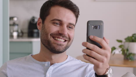 happy-young-man-having-video-chat-using-smartphone-enjoying-chatting-online-with-friend-relaxing-at-home