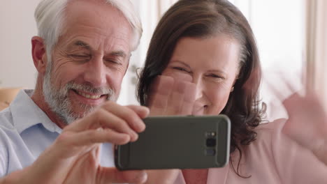 Glückliches-Paar-Mittleren-Alters,-Das-Ein-Smartphone-Nutzt-Und-Einen-Video-Chat-Führt,-Den-Enkeln-Zuwinkt-Und-Online-Kommunikation-Genießt,-Entspanntes-Altersheim