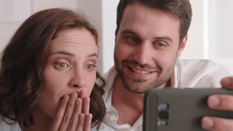 happy-couple-having-video-chat-using-smartphone-chatting-to-friend-looking-surprised-enjoying-online-communication-on-mobile-phone