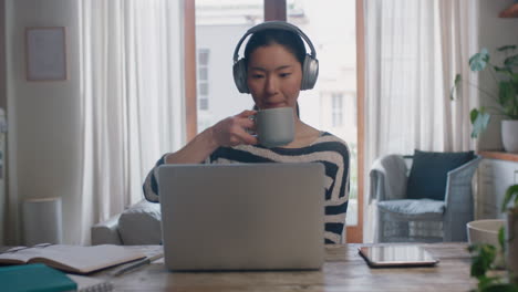 Junge-Asiatische-Frau,-Die-Einen-Laptop-Computer-Verwendet-Und-Von-Zu-Hause-Aus-Arbeitet.-Brainstorming-Projekt-Für-Studenten,-Informationsrecherche-Online,-Kaffeetrinken-Und-Genießen-Des-Lernens