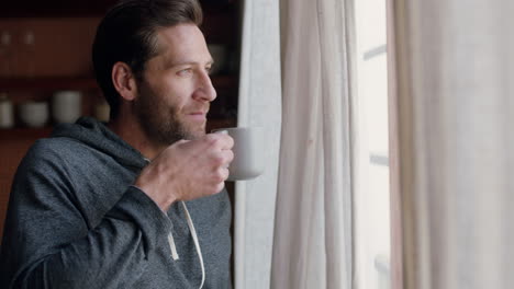 young-man-opening-curtains-looking-out-window-enjoying-fresh-new-day-feeling-rested-drinking-coffee-at-home