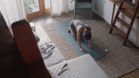 healthy-asian-woman-exercising-at-home-practicing-standing-forward-bend-pose-in-living-room-enjoying-morning-fitness-workout