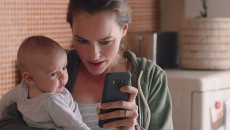 Junge-Mutter-Zeigt-Baby-Smartphone-Unterhaltung,-Die-Das-Kleinkind-Zu-Hause-Ablenkt