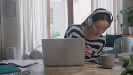 Junge-Asiatische-Frau,-Die-Einen-Laptop-Computer-Verwendet-Und-Von-Zu-Hause-Aus-Arbeitet.-Brainstorming-Projekt-Für-Studenten,-Recherche-Von-Informationen-Online,-Schreiben-Von-Notizen,-Genießen-Des-Lernens