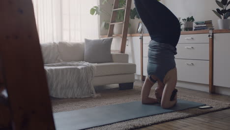 Gesunde-Yoga-Frau-Trainiert-Zu-Hause-Und-übt-Im-Wohnzimmer-Eine-Unterstützte-Kopfstandhaltung-Und-Genießt-Das-Morgendliche-Fitnesstraining