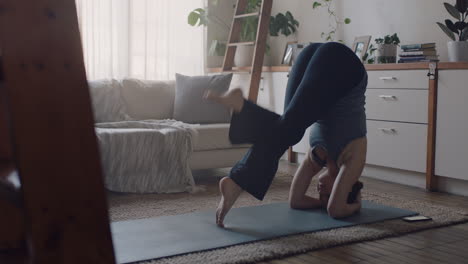 Gesunde-Yoga-Frau-Trainiert-Zu-Hause-Und-übt-Im-Wohnzimmer-Eine-Unterstützte-Kopfstandhaltung-Und-Genießt-Das-Morgendliche-Fitnesstraining