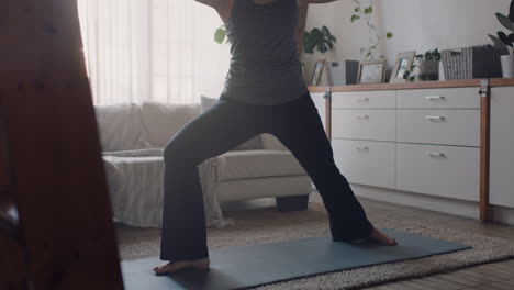 Gesunde-Yoga-Frau-Trainiert-Zu-Hause-Und-übt-Krieger-Pose-Im-Wohnzimmer-Und-Genießt-Das-Morgendliche-Fitnesstraining