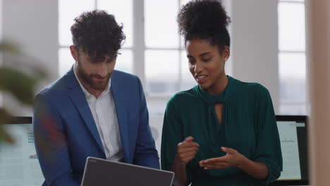 mixed-race-business-woman-team-leader-brainstorming-with-businessman-colleague-using-laptop-computer-showing-ideas-pointing-at-screen-working-together-in-office