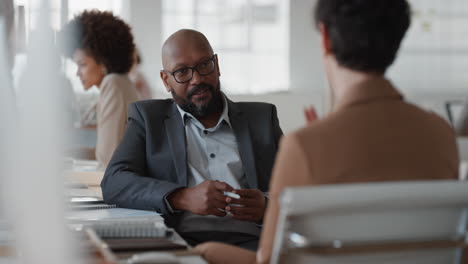 african-american-businessman-chatting-to-intern-discussing-job-interview-colleagues-having-conversation-in-office-enjoying-teamwork
