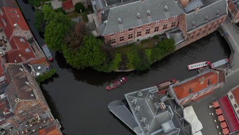 Kanal-Mit-Booten-Vogelperspektive-In-Brügge,-Belgien-Neigung-Nach-Oben,-Um-Stadtbild-Zu-Enthüllen