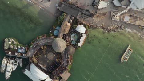 Scenic-Top-View-of-a-Beach-Festival-location-with-people-around-pool-in-tropical-Croatia,-Aerial-Overhead-Birds-Eye-View