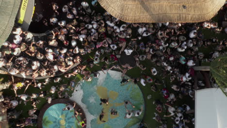 Vista-Superior-Genérica-Vista-De-Pájaro-Del-Club-De-Playa-Con-Piscina-Y-Gente-Bailando,-Toma-Aérea