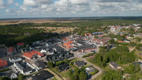 Aerial-panoramic-footage-of-buildings-in-small-town.-Flat-landscape-with-trees-surrounding-town.-Denmark