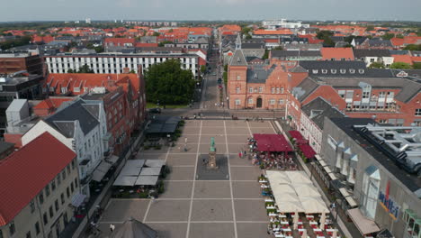 Aerial-view-of-the-famous-Torvet-square-in-Esbjerg,-Denmark-with-the-statue-of-Christian-IX-and-the-Kommune,-the-Town-Hall.-Backwards-revealing-Torvegade,-one-of-Denmark's-longest-pedestrian-streets