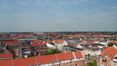 Aerial-view-flight-nearby-the-Water-Tower,-historical-monument-of-Esbjerg,-Denmark.-Drone-view-moving-towards-revealing-amazing-skyline-of-the-city-and-Torvet-square-with-the-statue-of-Christian-IX