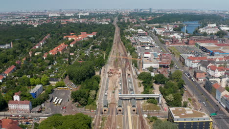 Aerial-view-of-S-bahn-train-driving-to-Schoneweide-train-station.-Maintenance-and-modernization-of-transport-infrastructure.-Tilt-up-reveal-of-city.-Berlin,-Germany