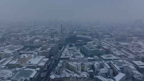 Aerial-panoramic-footage-of-snowed-buildings-in-city-centre.-Fly-above-long-straight-Friedrichstrasse.-Berlin,-Germany