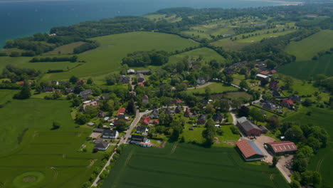 High-aerial-view-circling-around-small-suburbs-residential-area-in-Brodten,-Germany,-day