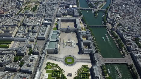 Forwards-fly-above-Louvre.-Aerial-view-of-complex-of-museum-buildings-on-Seine-river-waterfront.-Paris,-France