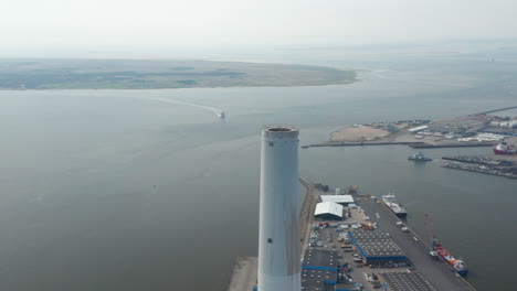 Aerial-view-flying-around-the-chimney-of-Esbjerg-Power-Station-in-Denmark.-Drone-view-orbit-revealing-the-harbor-and-the-stunning-skyline-of-the-city