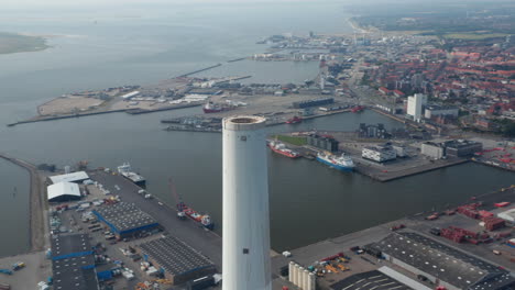 Aerial-view-of-the-chimney-of-the-Power-Station-of-Esbjerg,-Denmark.-Stunning-drone-view-of-the-skyline-of-the-city-with-brick-wall-in-background