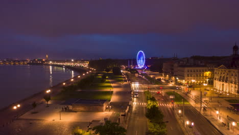 Hiperlapso-Nocturno-De-Burdeos,-Ribera-De-Francia-Con-Rueda-De-La-Fortuna,-Avance-Aéreo