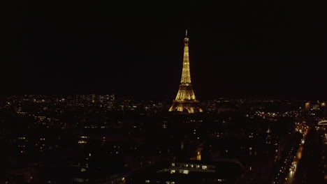 Toma-Aérea-Estática-De-La-Torre-Eiffel-Iluminada-Sobre-El-Centro-De-La-Ciudad-De-Noche.-Construcción-Alta-De-Acero-Con-Plataformas-De-Observación.-París,-Francia